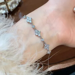 Elegant close-up of a sparkling zirconia flower bracelet worn on a wrist with soft feather detail