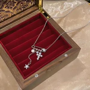 Elegante collana in argento con ciondolo a croce di zirconi, stella e perla su velluto rosso