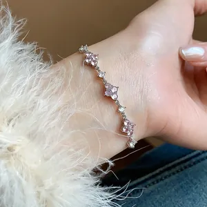 Detailed macro shot of elegant silver bracelet featuring pink and white zircon flowers.