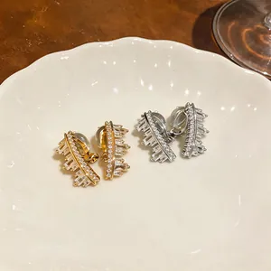 Macro detail of gold and silver irregular ear clips with sparkling cubic zirconia stones