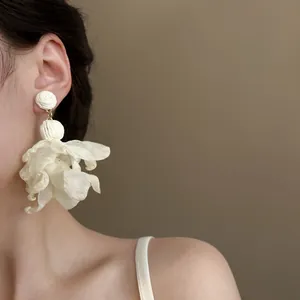 Detailansicht eleganter weißer Mesh-Blumen-Quastenohrringe für einen französischen Urlaubslook