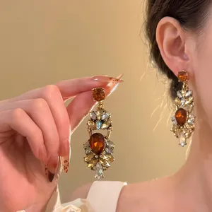 Close-up detail of amber zircon water drop fringe earrings on model ear