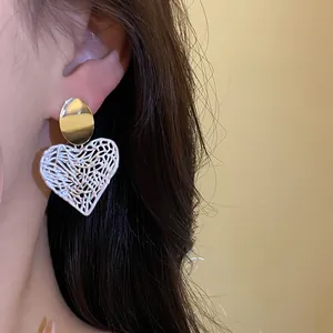 Detaillierte Nahaufnahme von elegantem herzförmigem hohlem Ohrring am Modellohr