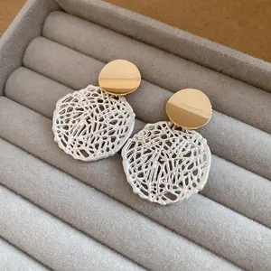 Nahaufnahme von eleganten gold-silbernen, ausgehöhlten Hängeohrringen in einem Display