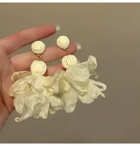 Detailansicht eleganter weißer Mesh-Blumenohrringe mit Quasten für den Urlaub