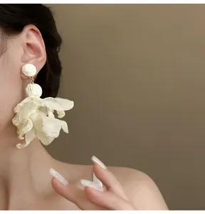 Detailaufnahme der weißen Netz-Blumen-Quasten-Ohrringe im französischen Feen-Stil.