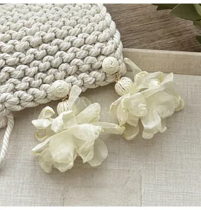 Detailansicht der übergroßen weißen Mesh-Blumenohrringe mit gewebten Akzenten für den Urlaub