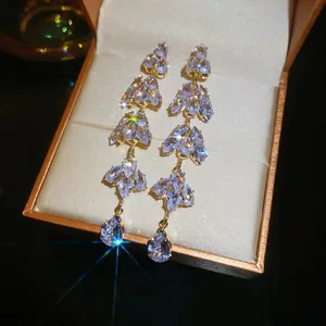 Close-up macro detail of luxury long crystal tassel earrings with sparkling teardrop stones