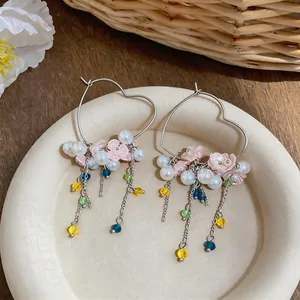 Detailed view of sweet heart-shaped hoop earrings featuring pearls and colorful bead tassels