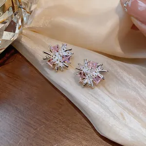Primo piano di eleganti orecchini a lobo a forma di fuoco d'artificio con zirconi rosa.