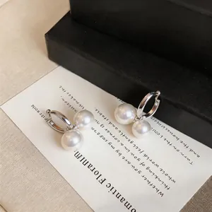 Detailansicht eleganter französischer Creolen aus Silber mit doppelten weißen Perlen
