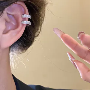 Close-up of a 18k gold plated cubic zirconia ear cuff sparkling on a woman's ear