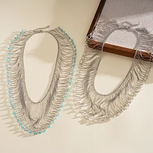 Detailed view of layered metallic tassel necklace with light blue crystal bead accents