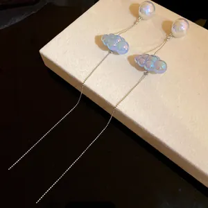 Dettaglio degli orecchini a nuvola blu cangianti con eleganti nappe a catenella in argento