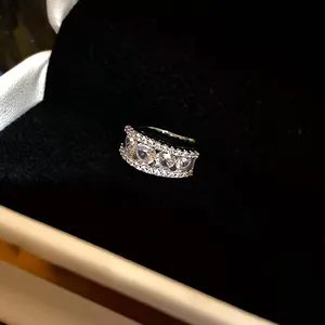 Macro detail of an 18k gold plated three-row zircon ear clip in a black jewelry box