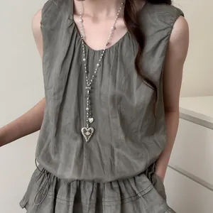 Close-up of a French-style long necklace with pearls and an elegant heart pendant.