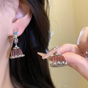 Close-up of elegant pink resin pudding earrings with sparkling multicolor zircons