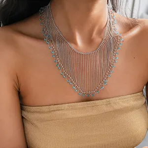Close-up showing the intricate texture of the silver fringe necklace with blue crystal beads