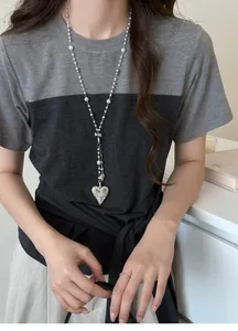 French vintage long necklace featuring white pearls and an engraved silver heart pendant