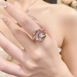 Close-up of a pink resin pudding ring with zircon accents on a finger