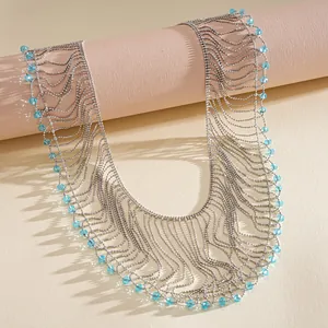 Detailed macro view of layered silver metal ball chain necklace with turquoise crystal beads.