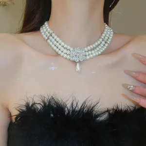 Choker français à trois rangs de perles avec fleur en strass et pendentif goutte