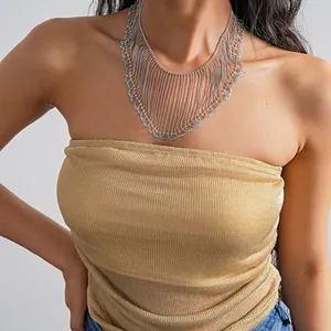 Detail view of an elegant crystal bead fringe statement necklace worn by a model.