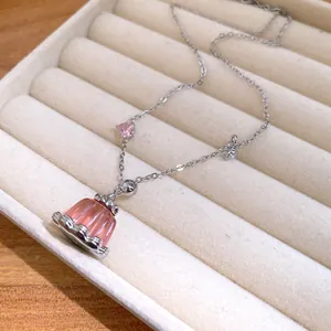 Detail view of a pink resin pudding pendant necklace with heart-shaped zircon stone.