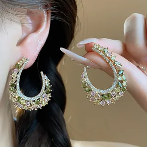 Dettaglio di orecchini a cerchio vintage in zircone con motivo spiga