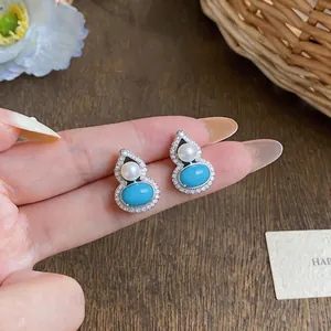 Detailed view of elegant gourd-shaped silver stud earrings with turquoise and pearls