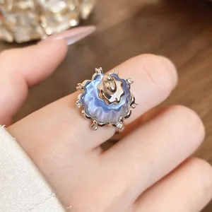 Close-up detail of a delicate blue resin pudding ring featuring elegant zircon accents