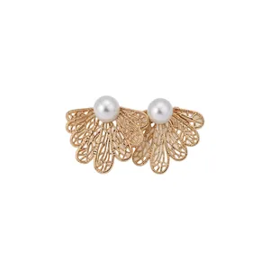 Elegantes pendientes de filigrana de hojas de oro con perlas blancas sobre blanco