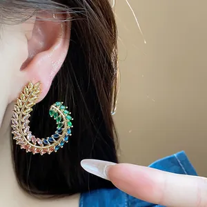 Dettaglio ravvicinato di orecchini a lobo in zircone multicolore a forma di spiga