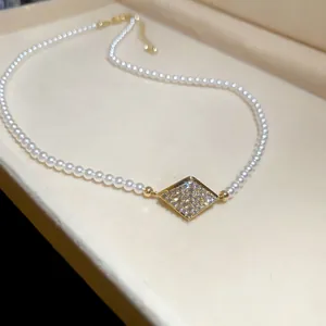 Close-up of vintage pearl necklace with square zircon pendant and 18K gold plating
