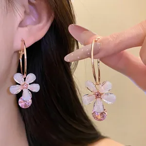 Elegant resin flower hoop earrings with sparkling pink zircon pendant on model ear