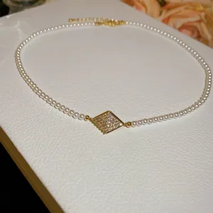 Detailed shot of an elegant 18K gold plated pearl necklace with a zircon pendant