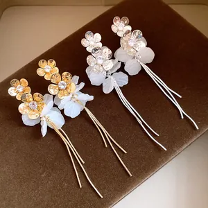 Vue détaillée d'élégantes boucles d'oreilles fleurs or et argent avec pétales