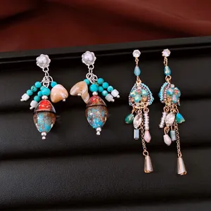 Vista detallada de dos pares de pendientes vintage de lujo con circonitas y perlas