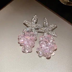 Detail von pinkfarbenen Kristallperlen-Ohrringen mit funkelnden Strassblumen-Steckern.