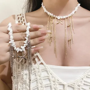 Detail of bohemian white stone necklace featuring gold starfish charms and long tassels