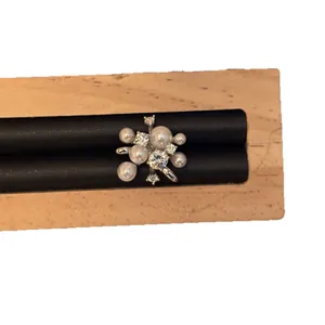 Elegante ear cuff con perle e zirconi a forma di fuoco d'artificio su supporto in legno