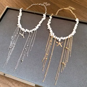 Detailed macro view of white stone beaded necklaces with gold and silver starfish tassels.