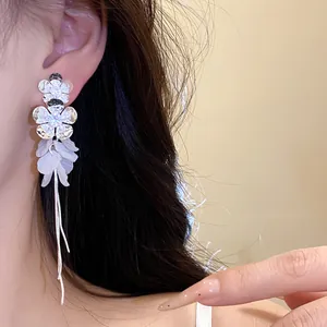 Détail rapproché de boucles d'oreilles fleur à pompons en zircon argenté