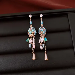 Vista detallada de elegantes pendientes vintage con cuentas turquesas y piedras circón