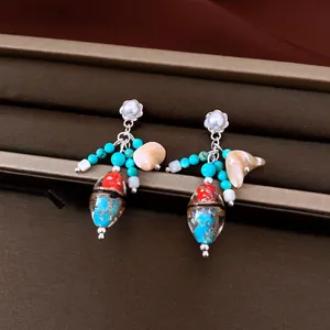 Detalle de pendientes vintage de plata con perlas y cuentas de cristal de colores vivos