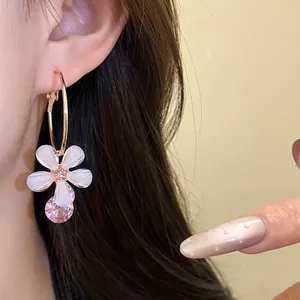 Close-up of elegant resin flower hoop earrings with pink zircon pendant for women.