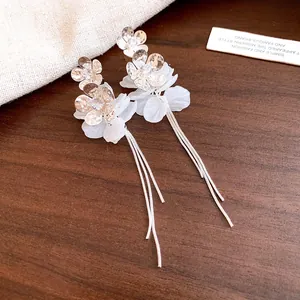 Gros plan d'élégantes boucles d'oreilles fleurs en argent avec pétales et glands