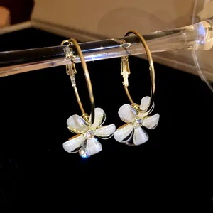 Close-up of elegant resin flower hoop earrings with sparkling zircon centers