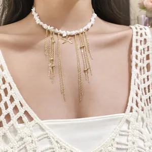 Close-up detail of white stone bead choker with starfish charm and gold chain tassels