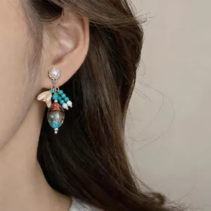 Vista detallada de elegantes pendientes vintage con perlas y cuentas de colores